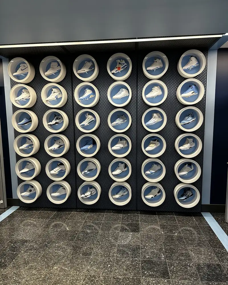 Custom display wall of circular shoe cubbies on a dark feature wall